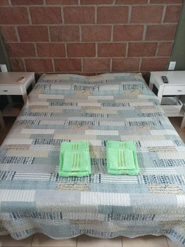 a bed with two green towels on top of it at Cabaña en Belén in Belén