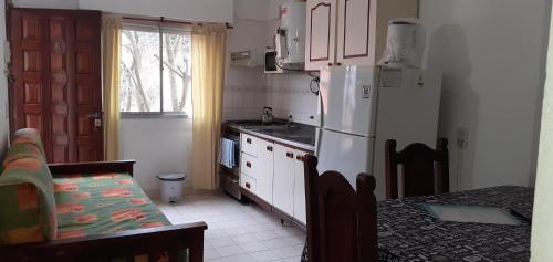 a kitchen with a white refrigerator and a table at Lo de Antonio Departamentos in Valeria del Mar