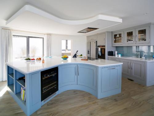 a kitchen with blue cabinets and a white counter top at Megizzy in Polzeath