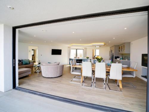 a dining room and living room with a table and chairs at Megizzy in Polzeath