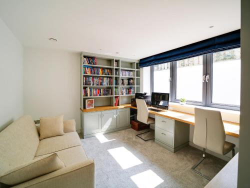 an office with a couch and a desk with a computer at Megizzy in Polzeath