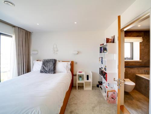 a bedroom with a bed and a bathroom with a tub at Megizzy in Polzeath