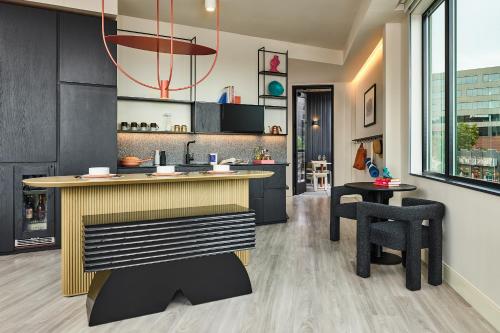 a kitchen with a counter and some chairs at Catbird Hotel in Denver
