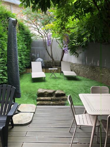 un patio trasero con sillas, mesa y fogata en Gite Aubusson, en Aubusson