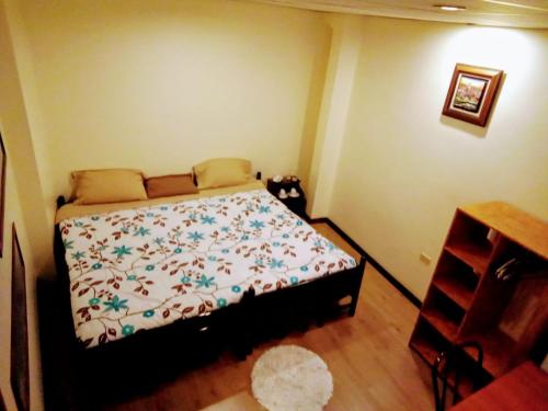 a bedroom with a bed and a wooden floor at Casa de Huéspedes Tu Parada en Cuenca in Cuenca