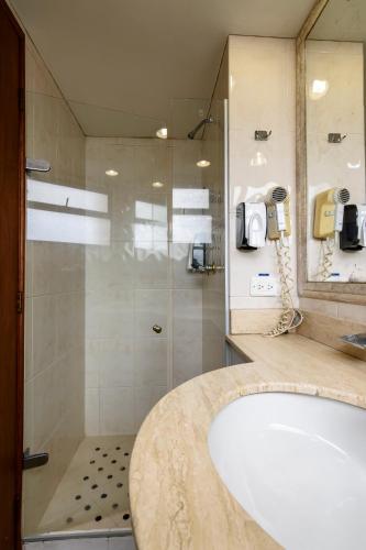 a bathroom with a sink and a shower and a tub at Hotel Cabo de la Vela Medellin in Medellín