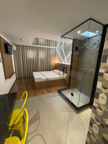 um quarto com uma cama e uma cadeira amarela em Hotel Cantareira (Adults Only) em São Paulo