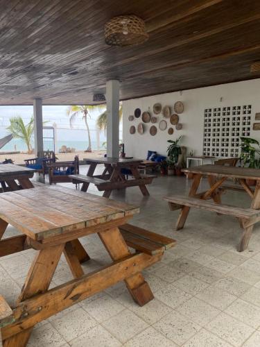 a group of picnic tables in a room with the beach at Casa Greca in Playa Blanca