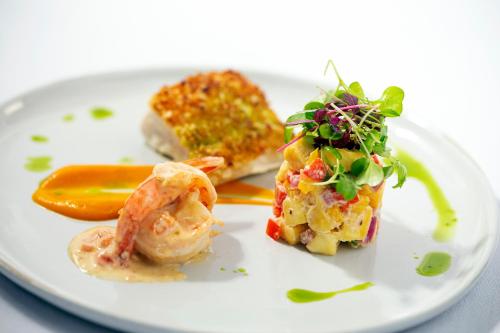 a plate of food with shrimp and a pickle at Ti Kaye Resort & Spa in Anse La Raye