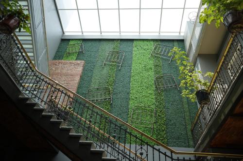 a stairway with chairs and a garden in a building at Hotel Principal in Mexico City