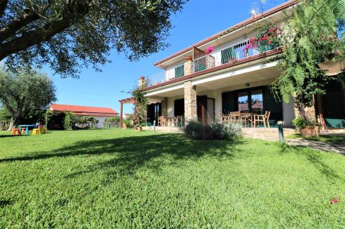 una casa con césped delante en Villa di Marinella en Ascea