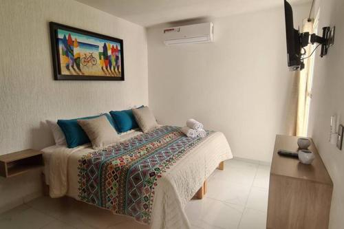 une chambre avec un lit et un tableau au mur dans l'établissement Penthouse con Roof Garden, experiencia sin igual., à Manzanillo