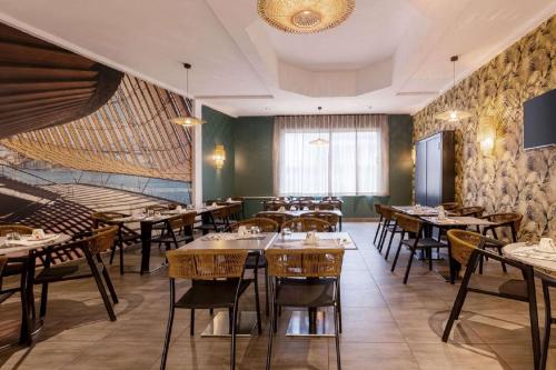 a restaurant with tables and chairs in a room at Best Western Plus Hôtel Belfort Centre Gare in Belfort