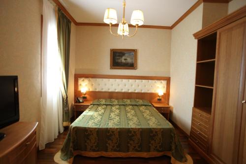 a bedroom with a bed and a chandelier at Hotel Borgo Don Chisciotte in Modica