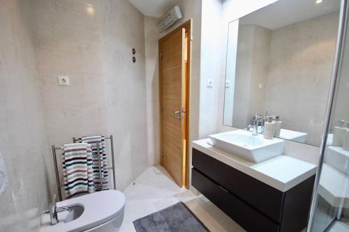 a bathroom with a sink and a toilet and a mirror at Cozy Orange Telheiras Apartment in Lisbon