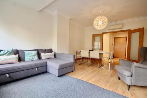 a living room with a couch and a table at Cozy Orange Telheiras Apartment in Lisbon