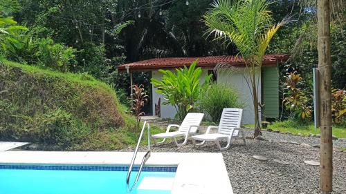 um grupo de cadeiras sentadas ao lado de uma piscina em Selva Linda Lodge vacation rentals em Quepos