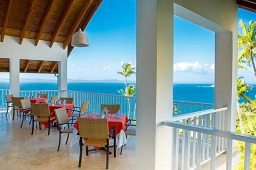 a dining room with a view of the ocean at Vista Mare Spectacular Ocean View Spacious 2-Bedroom Condo, Samana in Santa Bárbara de Samaná