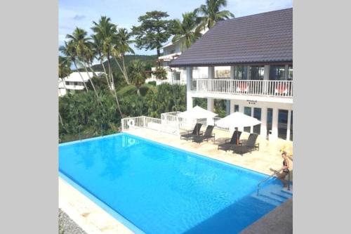an image of a swimming pool in front of a house at Vista Mare Spectacular Ocean View Spacious 2-Bedroom Condo, Samana in Santa Bárbara de Samaná
