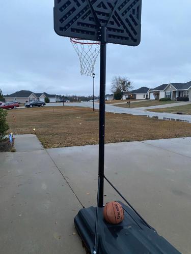 a basketball hoop with a basketball on a sidewalk at Home away from Home in Statesboro