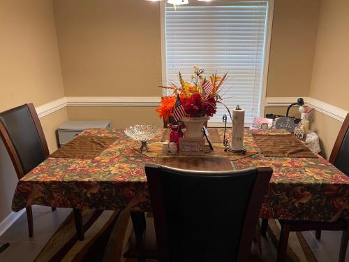 a dining room table with a table cloth and flowers on it at Home away from Home in Statesboro