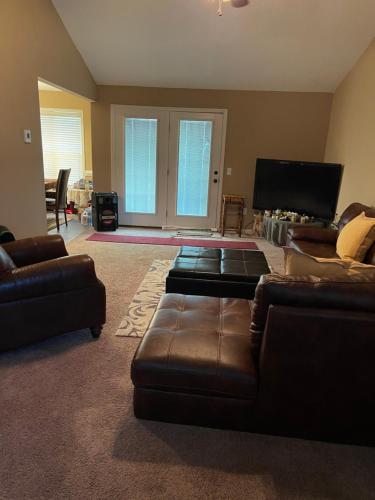 a living room with couches and a flat screen tv at Home away from Home in Statesboro