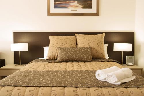 a bedroom with a bed with two towels on it at Comfort Inn & Suites Augusta Westside in Port Augusta