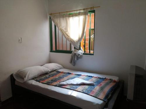 a bed in a room with a window at Hosteria los Cristales in Santander de Quilichao