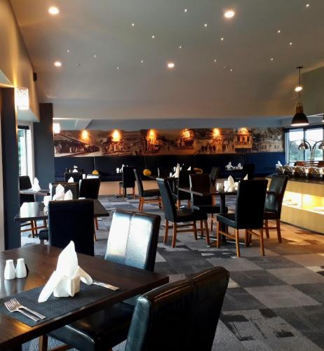 a restaurant with tables and chairs and a bar at Beachcomber Inn Picton in Picton