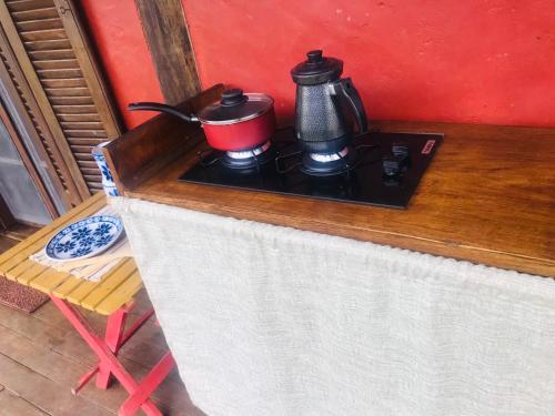 a stove with a pot and a tea kettle on it at Cabana Lua - Praia de Castelhanos in Ilhabela