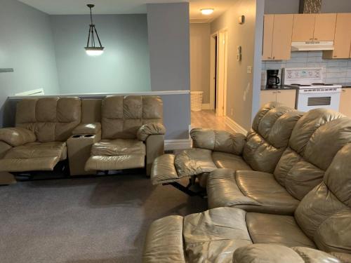 a living room with couches and a couch and a kitchen at Ottawa airport guesthouse in Ottawa
