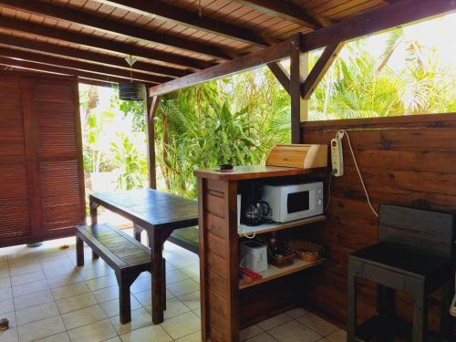 a small kitchen with a table and a microwave at Gites Kaladja in Port-Louis