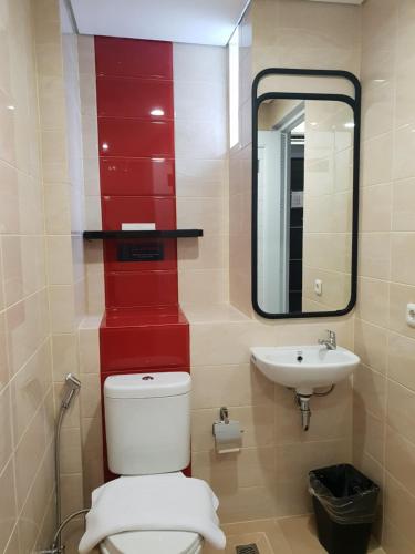a bathroom with a toilet and a sink at Sambina Prime by Danapati in Jakarta
