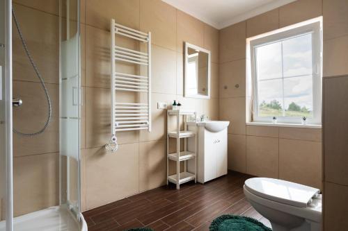 a bathroom with a toilet and a sink and a window at 2 House Between Two Lakes in Vilnius