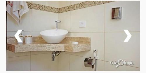 a bathroom with a white bowl sink on a counter at Recanto Primavera in Olímpia