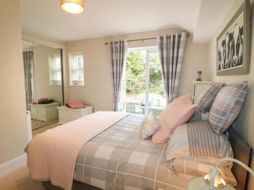 um quarto com uma cama com almofadas cor-de-rosa e uma janela em Millcott em Lincoln