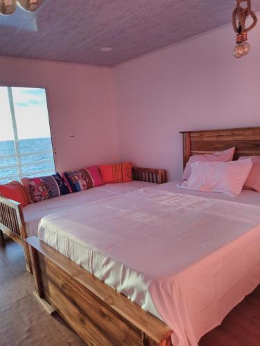 a bedroom with a large bed and a large window at posada donde Uriel Playa tranquila in Baru