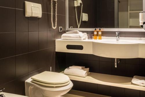 a bathroom with a toilet and a sink at Point Hotel in Piove di Sacco