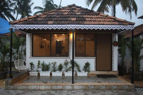a small white house with a porch with plants at Veda5 Wellness Retreat & Spa in Old Goa