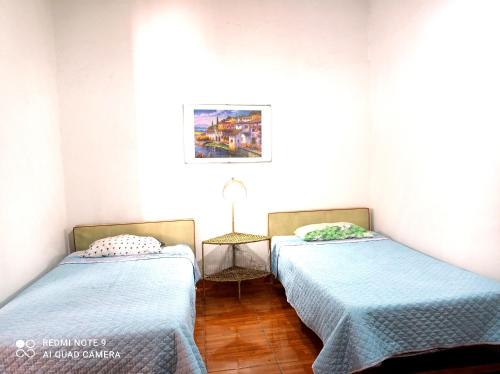 two beds in a room with blue sheets at La Posada Del Misti in Arequipa