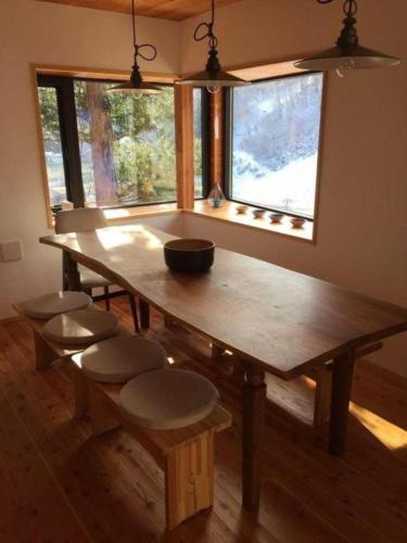 a wooden table with a bowl on it in a room with a window at Fuku Chalet in Hakuba