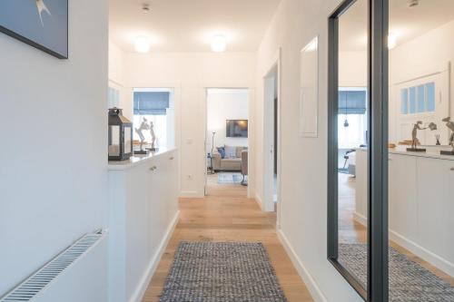 a hallway of a home with white walls and a mirror at Seeschwalbe in Husum