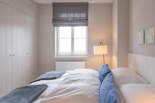 a white bedroom with a bed and a window at Seeschwalbe in Husum