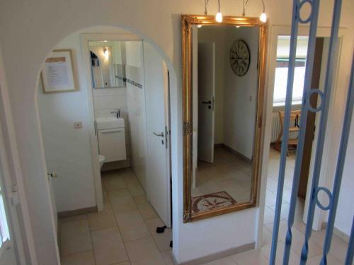 - une salle de bains avec un miroir à côté d'un couloir dans l'établissement Ferienhaus im Kanalblick, à Osterrönfeld