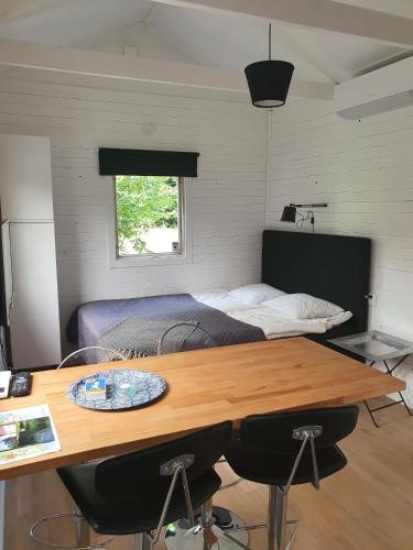a bedroom with a bed and a wooden table with chairs at Skogsbäckens stugby AB in Tomelilla