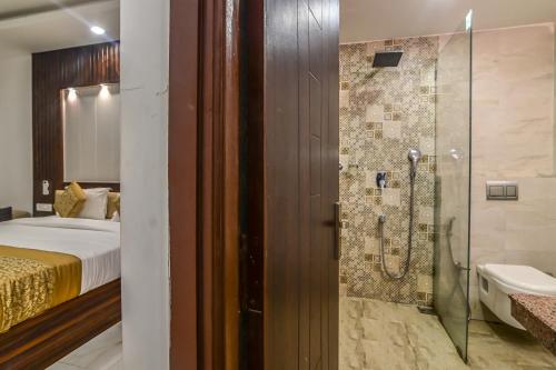 a bathroom with a shower and a bed and a tub at De Falcon Goa Beach Resort in Candolim