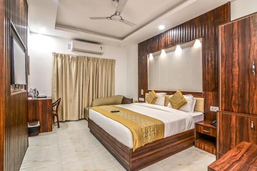 a hotel room with a bed and a desk at De Falcon Goa Beach Resort in Candolim