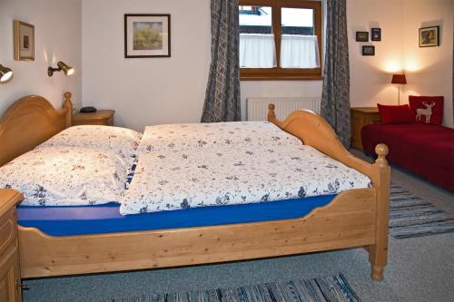 基茨比厄爾的住宿－Haus Savoy - Appartement 4，一间卧室配有一张带蓝色床垫的木床