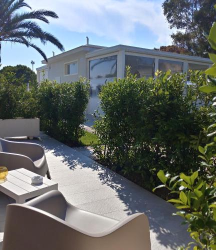 a patio with white chairs and a house at SALAPIA SALIS RESORT in Margherita di Savoia