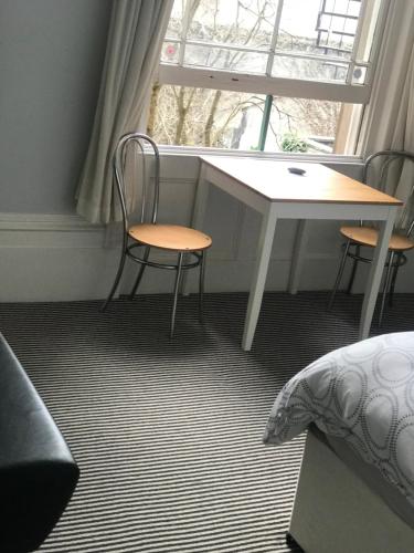 a room with a table and two chairs and a window at Studio flat Brighton Hove border in Brighton & Hove
